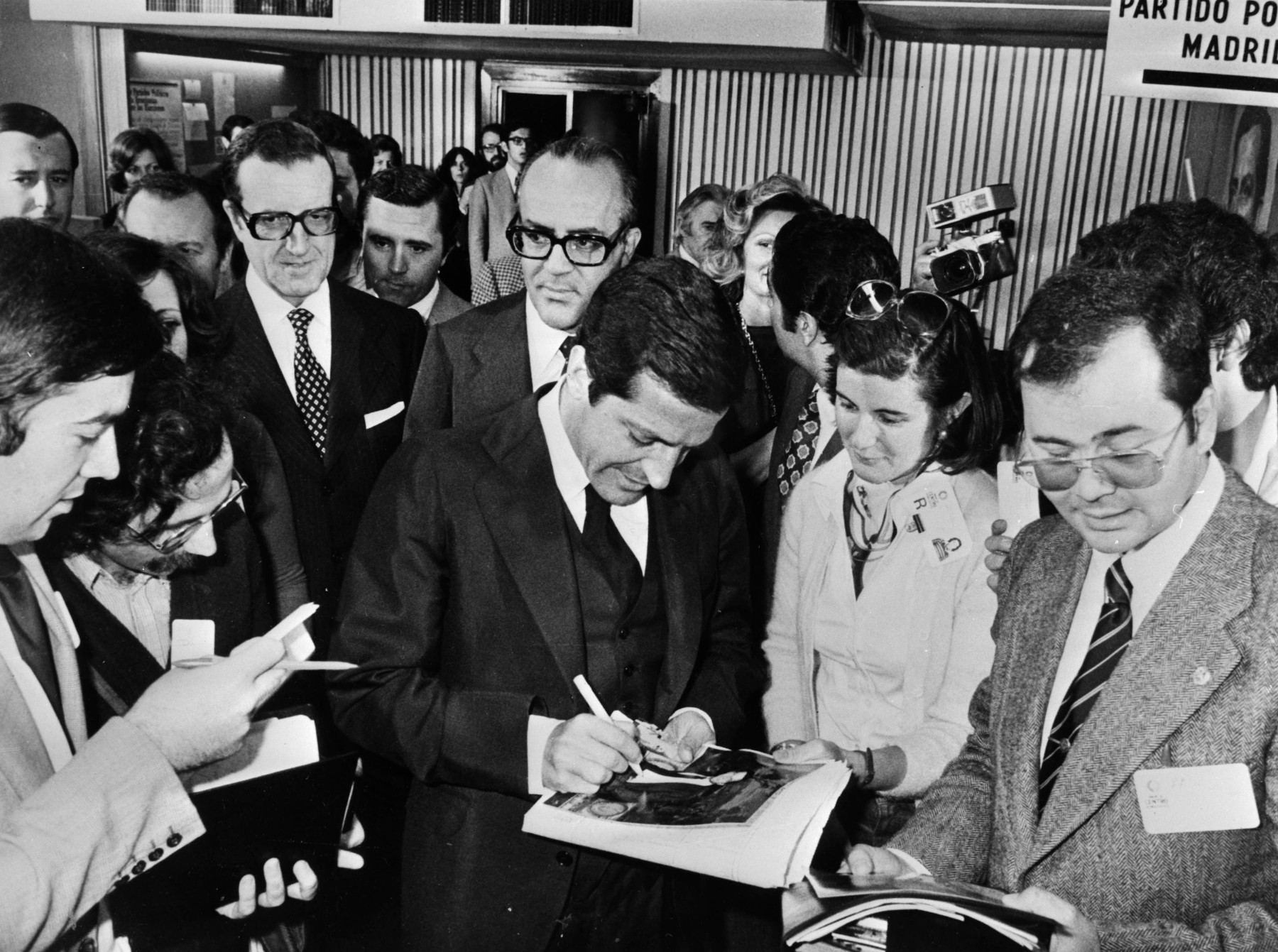 El Presidente Adolfo Suárez firma autógrafos detrás el exministro Leopoldo Calvo Sotelo 13-06-1977. Colección ANEFO.
